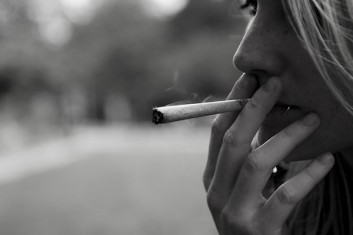 Una giovane ragazza ritratta mentre fuma uno spinello