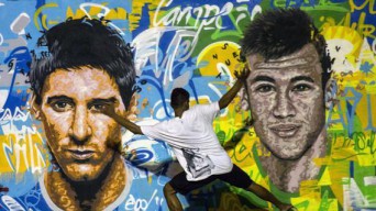 Giovane brasiliano gioca a calcio a piedi nudi davanti a Messi e Neymar immortalati in un graffito